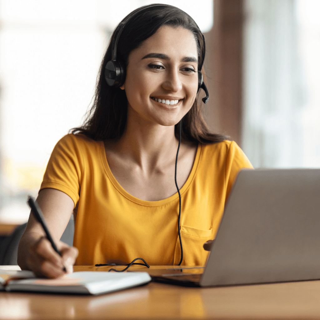 A girl taking notes while attending a course/webinar online